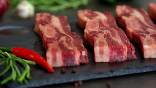 Raw Beef Ribs with Seasoning Spices Close Up of Pieces of Beef Steak on Bone