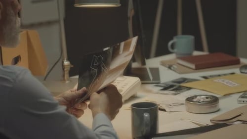 FBI Agent Examining Crime Scene Photos in Office
