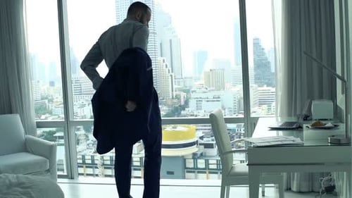 Man Takes Off Suit Jacket in Hotel Room