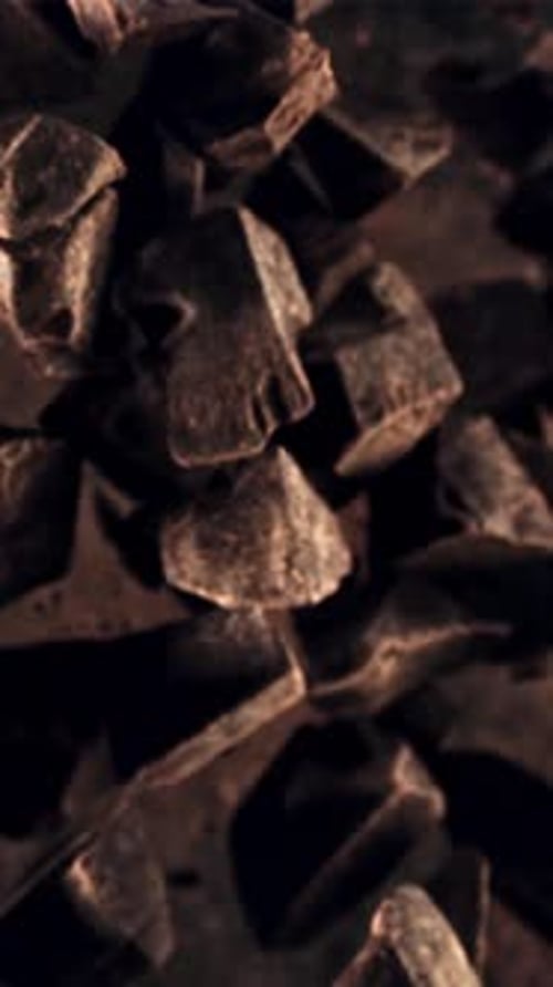 Pieces of Chocolate Fly Apart and Rotate in Flight Filmed is Slow Motion 1000 Fps