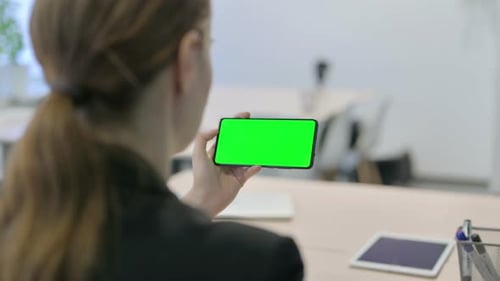 Businesswoman Holding Horizontal Smartphone with Green Screen