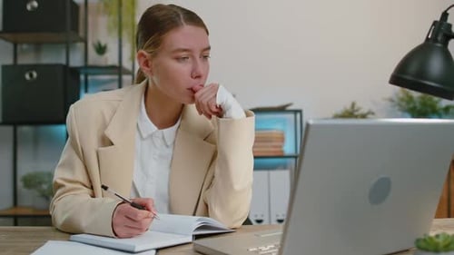 Businesswoman Lawyer in Suit Working on Laptop Online Writing Notes in Planner Notebook at Office