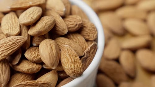 Mandelkerne in weißer Schale, rotierender Nusshaufen, Konzept für gesundes veganes Essen