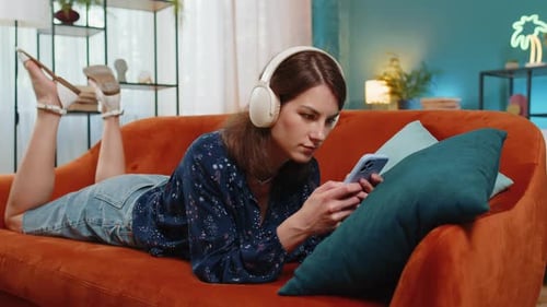 Woman Relaxes on Couch Using Cellphone