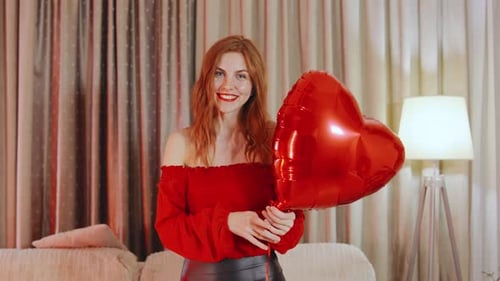 Smiling Woman Holds a Heart-Shaped Balloon