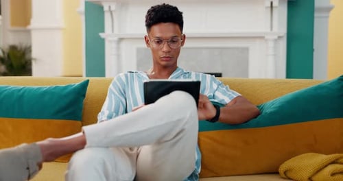 Search, relax and tablet with man on sofa for online reading, communication and social media post