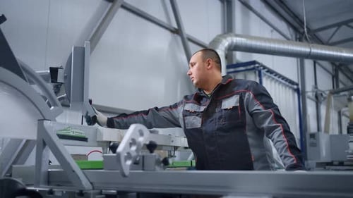 Operator of CNC Machine for Cutting Boards in Woodworking Workshop Adjusting Modern Equipment
