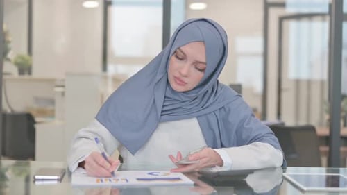 Woman Counting Money and Making Notes in Office