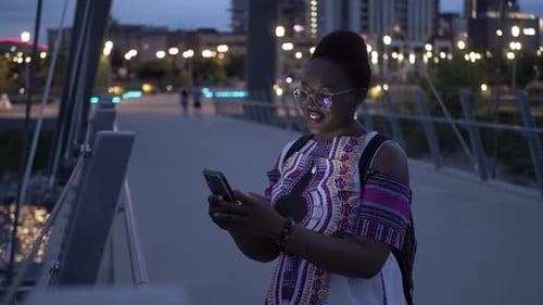 Woman Using Smartphone on Urban Bridge at Night