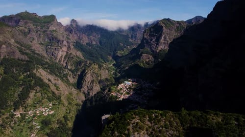 Aerial view of a small town in the middle of mountain range. Madeira landscape.