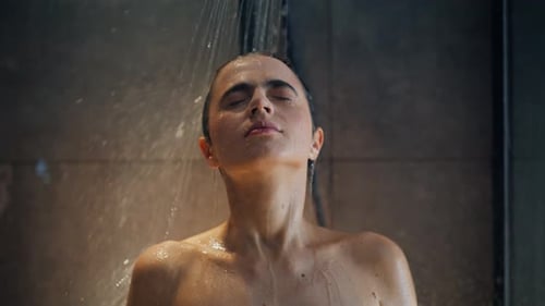 Nahaufnahme Nasse Frau genießt Wassertropfen im Waschraum Sexy Brünette wäscht Haare