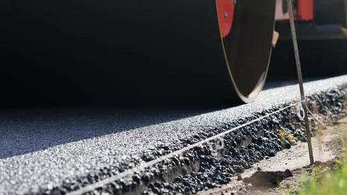 Road Roller Compacting Fresh Asphalt During Highway Construction and Road Paving