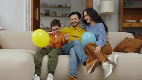 Joyful Family Celebrates with Balloons Indoors