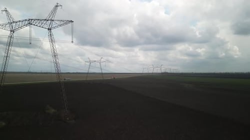 Aerial View of Power Lines Over Green Agricultural Field