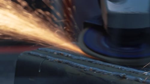 Techniker verwenden einen elektrischen Rotationsschleifer zum Schneiden und Schleifen von Strukturmetallmaterial. Mechaniker...