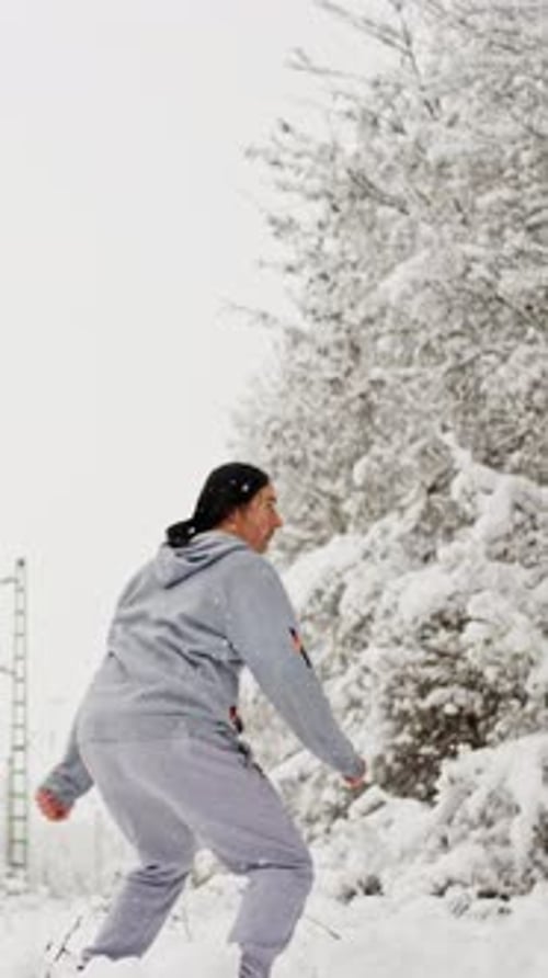 Athletic Man Practicing Martial Arts in Snow-Covered Forest