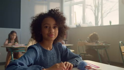 Young girl in classroom looking at camera