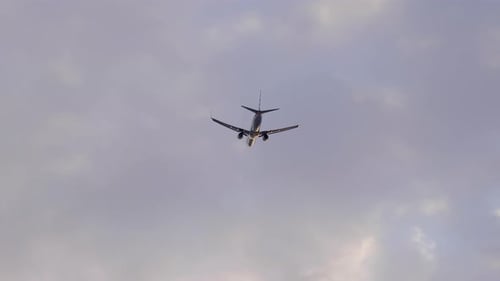 Avião voando no céu contra o céu nublado. - ângulo baixo