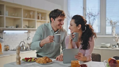 Couple Looking Tablet Drinking Morning Coffee Together at Kitchen Close Up