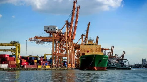 Cargo Ship Docked at Urban Port with Cranes