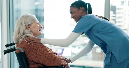 Compassionate Nurse Comforting Senior Woman in Wheelchair