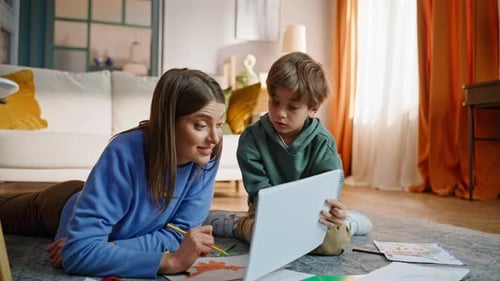 Woman and Boy Drawing with Colored Pencils at Home