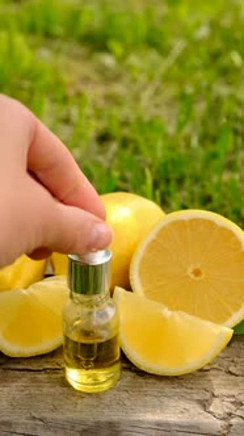 Lemon Essential Oil Being Dispensed From Dropper Outdoors