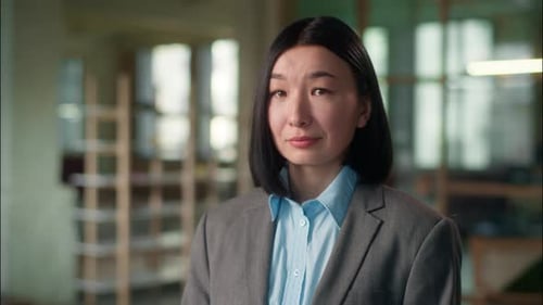 Woman in Blazer Looking at Camera in Office
