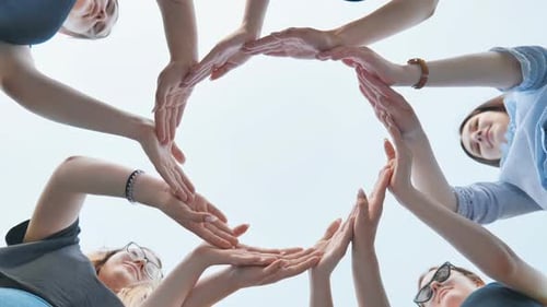 Friends Make a Circle with Their Palms Against the Blue Sky