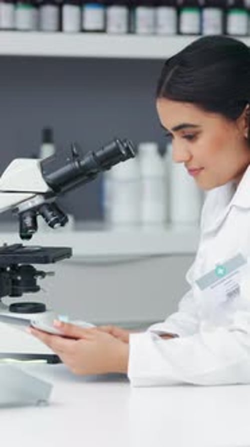 Microscope, science and tablet with woman in laboratory for medical development or research