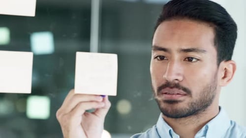 Man Writes Ideas on Sticky Notes in Office