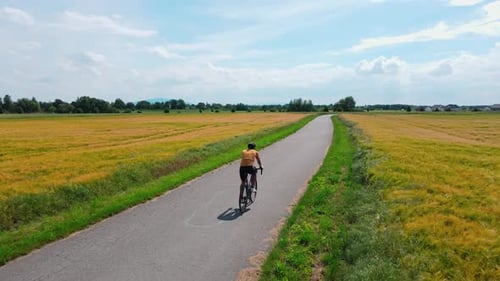 Mann fährt Rennrad auf Landweg während des Radfahrertrainings an sonnigen Tagen