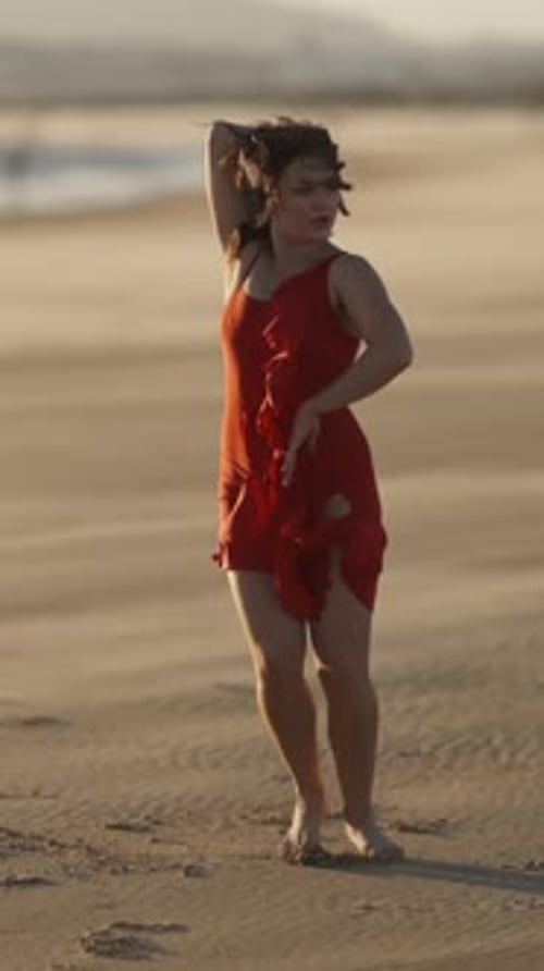 Woman Dancing on the Beach in Red Dress