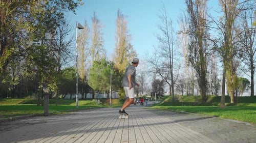 Man Ride Skateboard in Park Summer Day