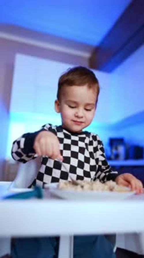 Child Eating Food at the Table with a Fork