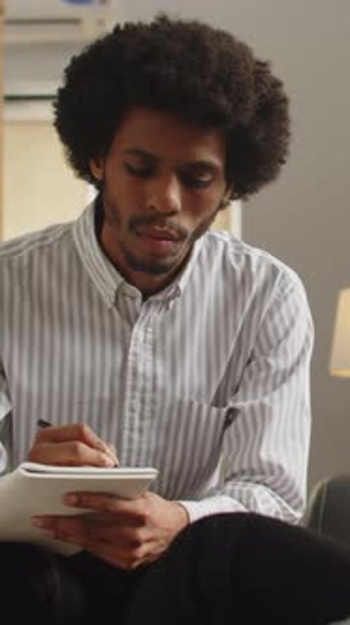 Young Adult Taking Notes at Meeting