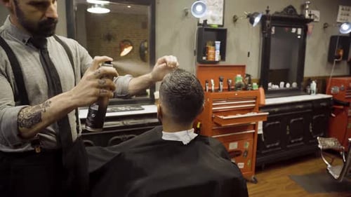 Professional Hairdresser Using Hair Spray On Client Hair At Barber Shop - close up
