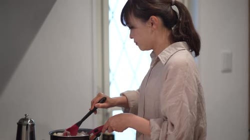 Woman Cooking in Kitchen with Spatula