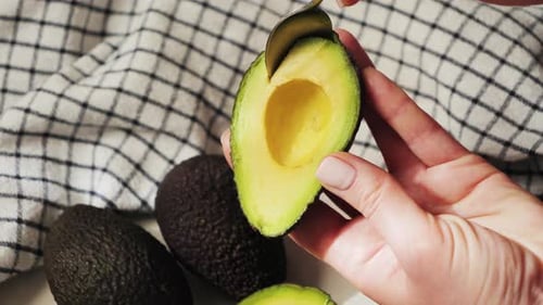 Preparing Tasty Avocado with Spoon in Kitchen