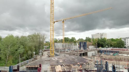 La grúa transporta materiales mientras se construye la base de concreto