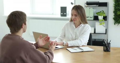 Recruteur avec ordinateur portable et candidat ayant un entretien d'embauche à table au bureau