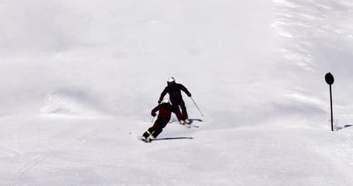 2 männliche Skilehrer fahren kurze Skikurven. Guter Rhythmus mit wunderschöner Skitechnik
und Eleganz