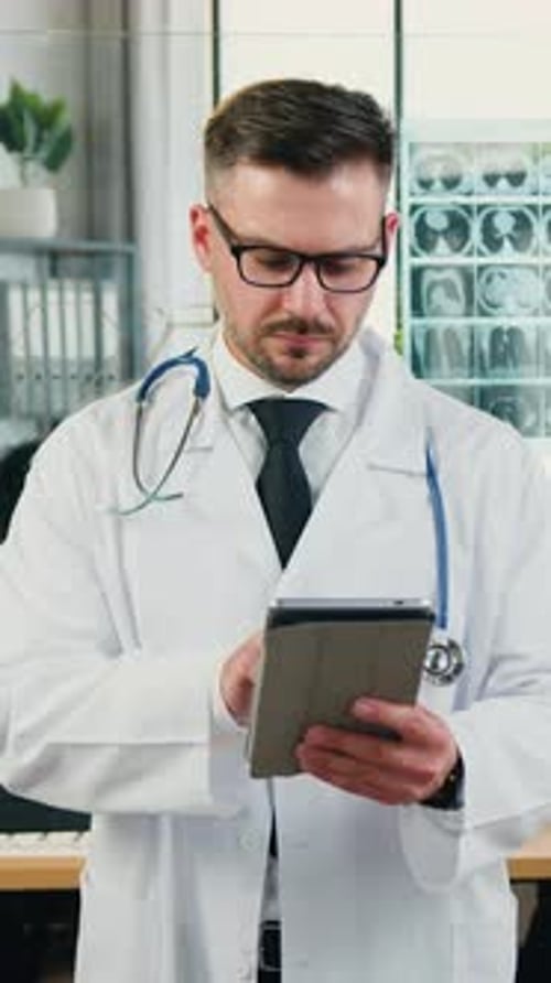 Male Doctor Using Tablet Computer in Hospital Setting