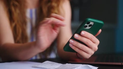 Woman Enters Data from Receipt into Her Phone