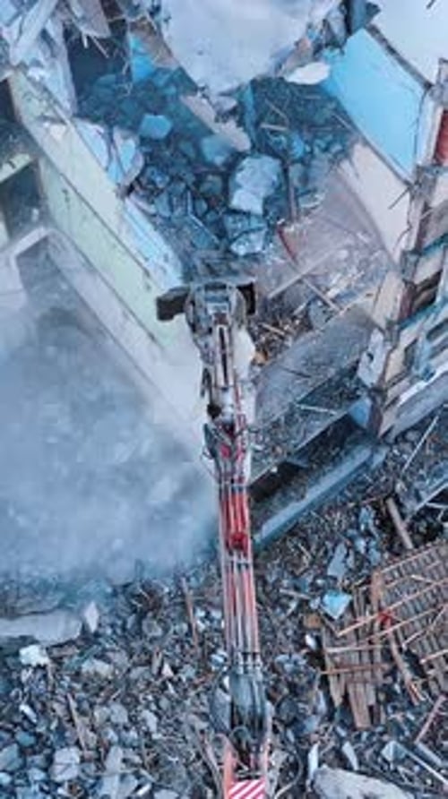 Demolishing machinery breaks the floors and walls of the ruin.