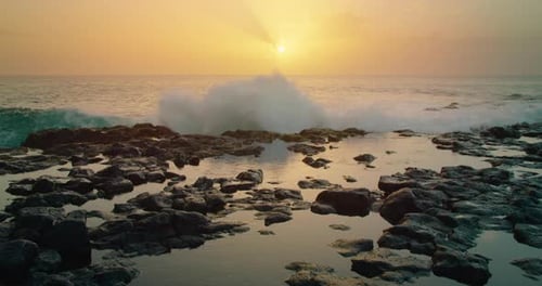 Stormy Pacific Ocean Waves Breaking on Wet Sea Cliffs Rocks with White Splashes on Cinematic Golden