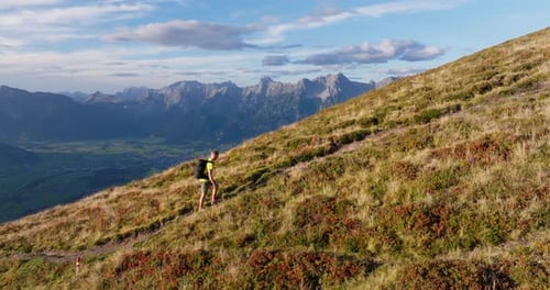 Male Hiker On Sunlit Path Towards The Peak Of The Mountain