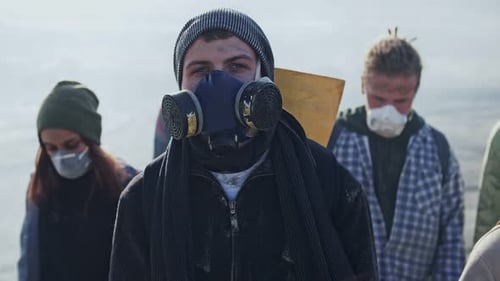 Young Adults in Masks Walk Through Disaster Area