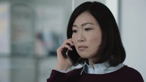 Japanese business woman in office talking on phone