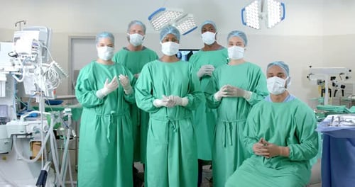 Portrait of diverse surgeons wearing surgical gowns in operating theatre, slow motion